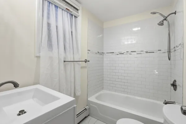 a bathroom with a tub a sink and a shower