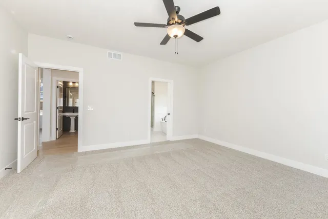 an empty room with closet and a ceiling fan
