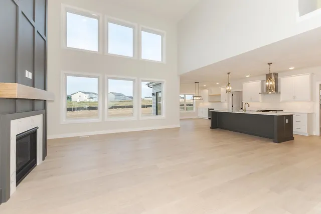 a view of a kitchen with a sink a fireplace and windows