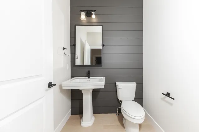 a bathroom with a toilet sink and mirror