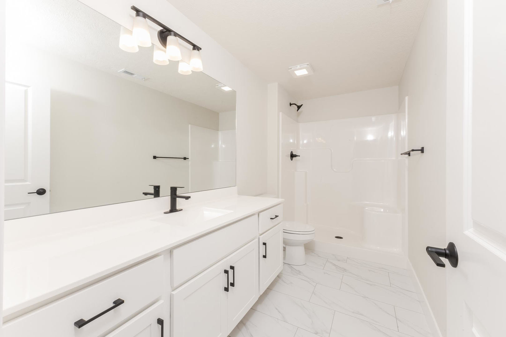 1009 Mount Carmel Road Bloomington, IL 61705 - Photo 36 of 39 a spacious bathroom with a granite countertop sink a mirror and a vanity