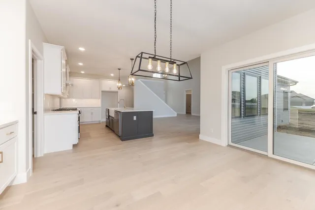 a living room with couches and kitchen view with wooden floor