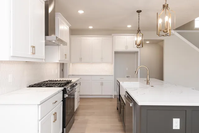 a kitchen that has a sink a stove and wooden cabinets
