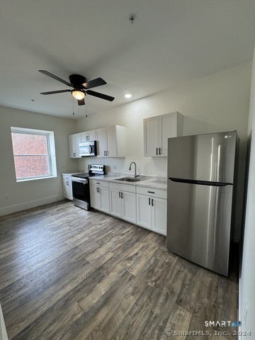 61 Colony Street, Unit 3C Meriden, CT 06451 - Photo 1 of 8 a kitchen with stainless steel appliances granite countertop a refrigerator a sink dishwasher a stove with wooden floor and cabinets