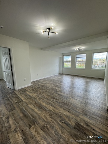 61 Colony Street, Unit 3C Meriden, CT 06451 - Photo 2 of 8 a view of an empty room with window and wooden floor