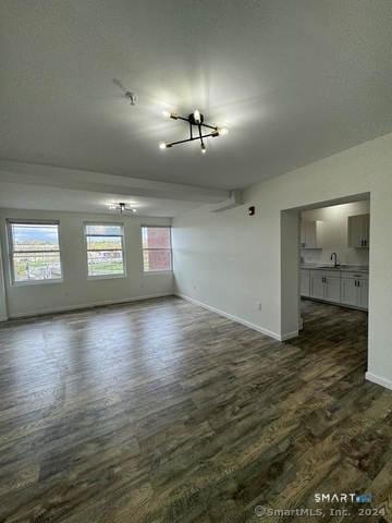 61 Colony Street, Unit 3C Meriden, CT 06451 - Photo 3 of 8 an empty room with wooden floor and mirror