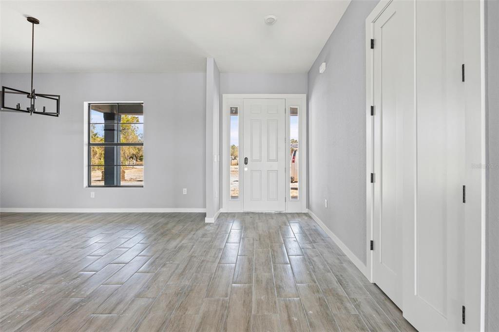 6137 Grove Boulevard Punta Gorda, FL 33982 - Photo 13 of 28 a view of an empty room with wooden floor and a window