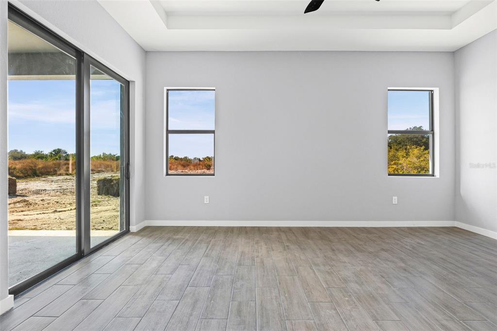 6137 Grove Boulevard Punta Gorda, FL 33982 - Photo 16 of 28 a view of an empty room with a window and wooden floor