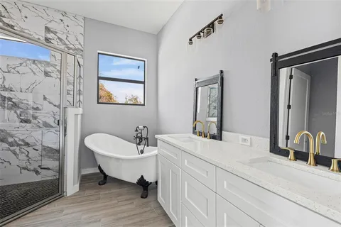 a spacious bathroom with a double vanity sink a mirror and a bathtub