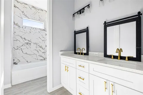 a bathroom with a bathtub sink and mirror