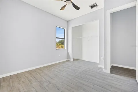 an empty room with a window and wooden floor