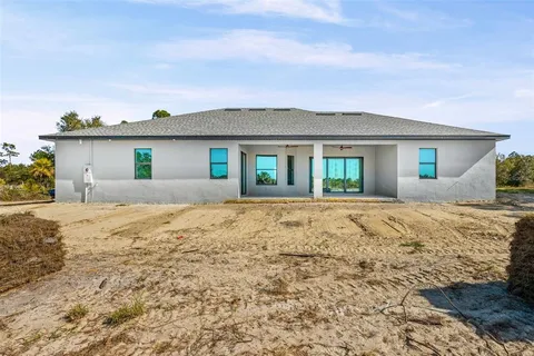 a front view of house with yard and ocean