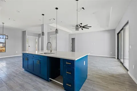 a view of a kitchen with kitchen island a sink wooden floor and window