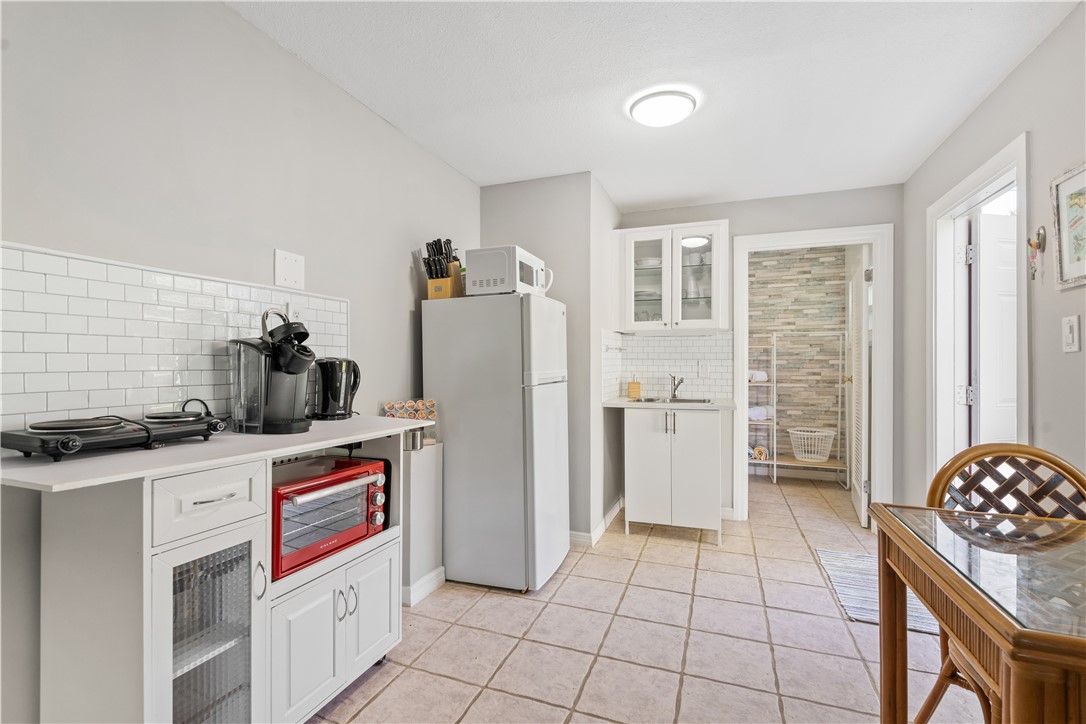 1621 5th Avenue Vero Beach, FL 32960 - Photo 28 of 35 a kitchen with stainless steel appliances kitchen island granite countertop a refrigerator and a stove top oven