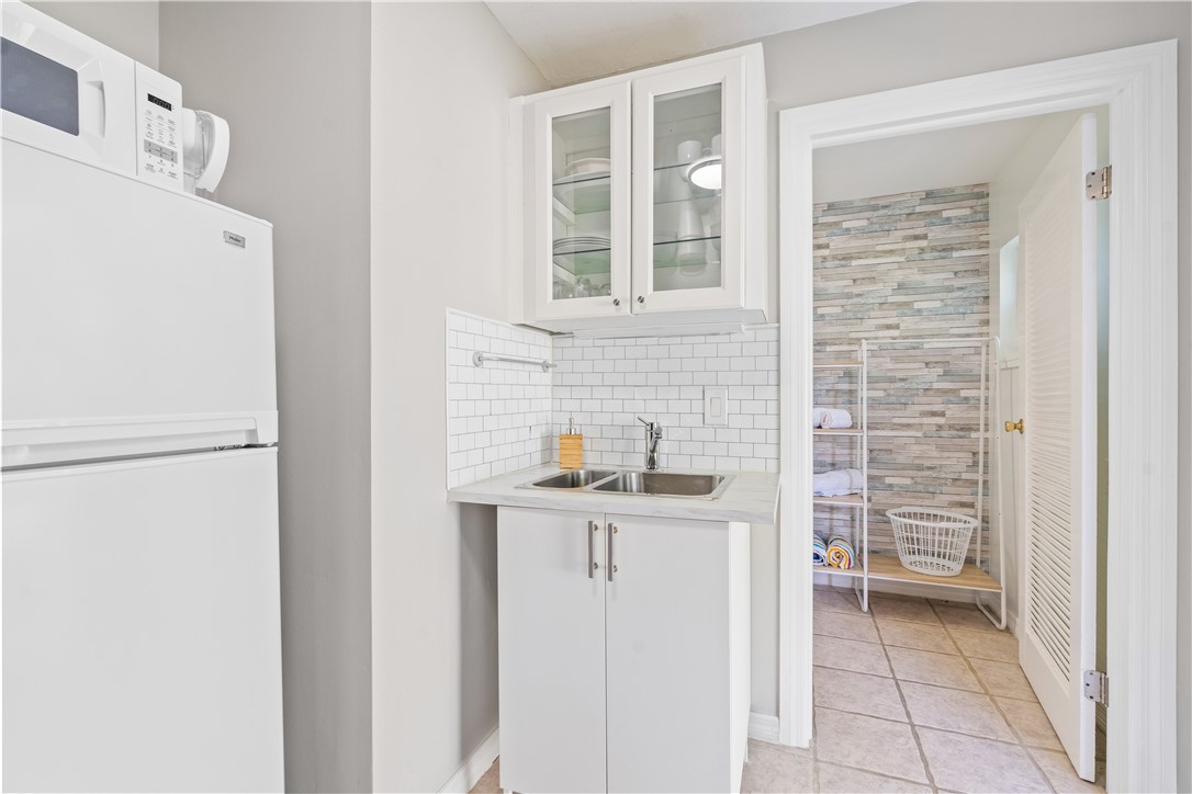 1621 5th Avenue Vero Beach, FL 32960 - Photo 29 of 35 a kitchen with stainless steel appliances granite countertop a sink and a refrigerator