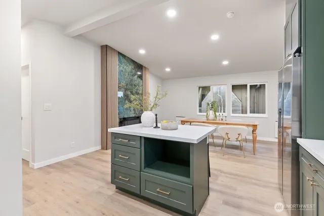 a view of kitchen island with stainless steel appliances granite countertop a stove and a sink