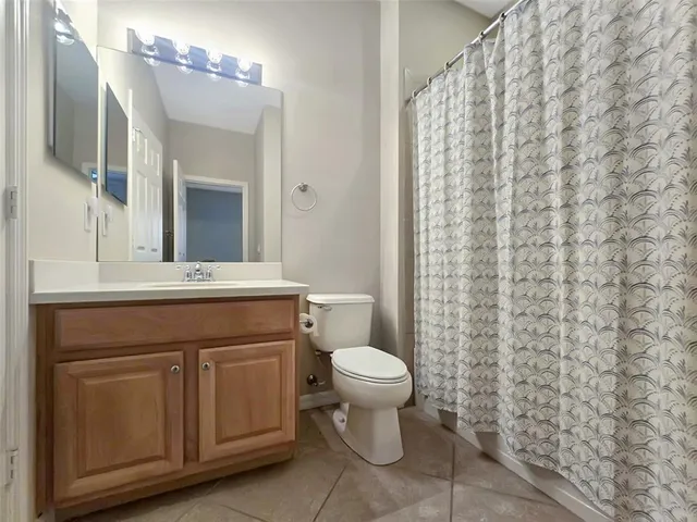 a bathroom with a sink a toilet and shower curtain
