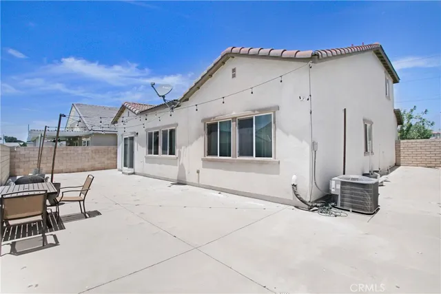a view of a white house with chairs in patio