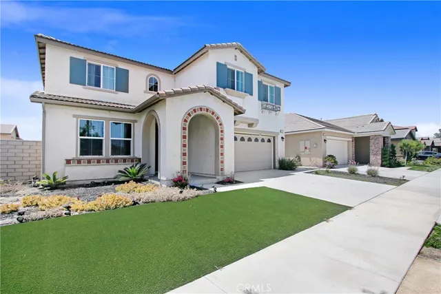 a front view of a house with a garden and plants