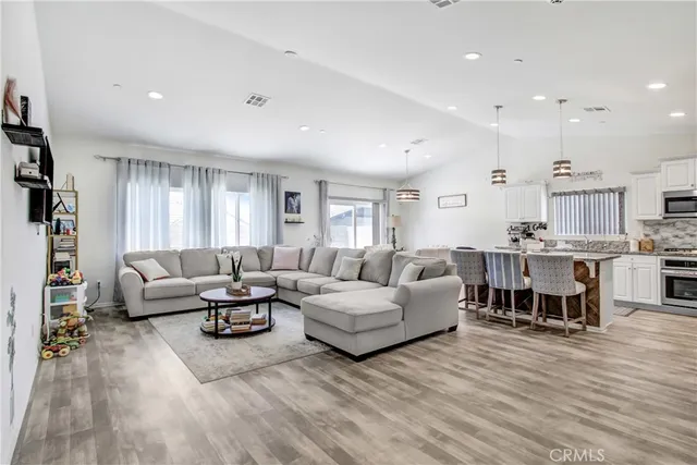 a living room with lots of furniture and kitchen view