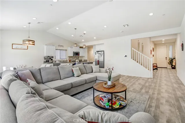a living room with furniture and a view of kitchen