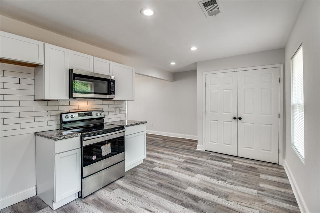 1201 Ridgewood Road Denison, TX 75020 - Photo 9 of 29 Kitchen with stainless steel appliances, dark stone countertops, white cabinets, and light hardwood / wood-style flooring