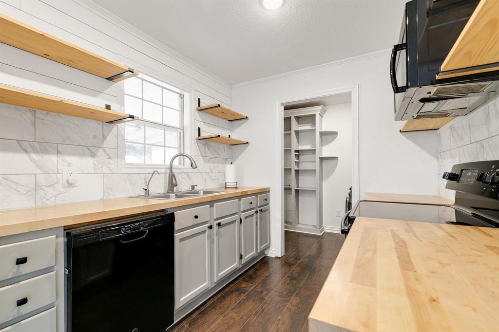 1325 Pilot Grove Road Whitewright, TX 75491 - Photo 13 of 30 Kitchen with open shelves, decorative backsplash, black appliances, dark wood finished floors, and white cabinetry