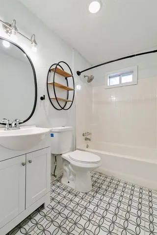 a bathroom with a toilet a sink and a mirror
