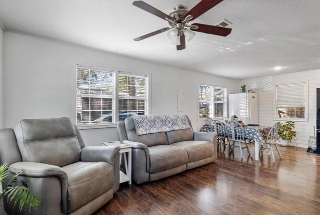 a living room with furniture and wooden floor