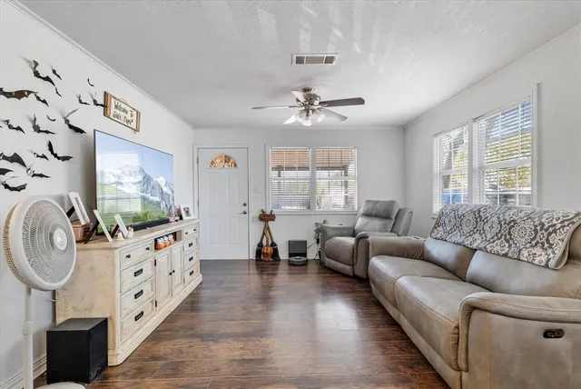 a living room with furniture a flat screen tv and a window