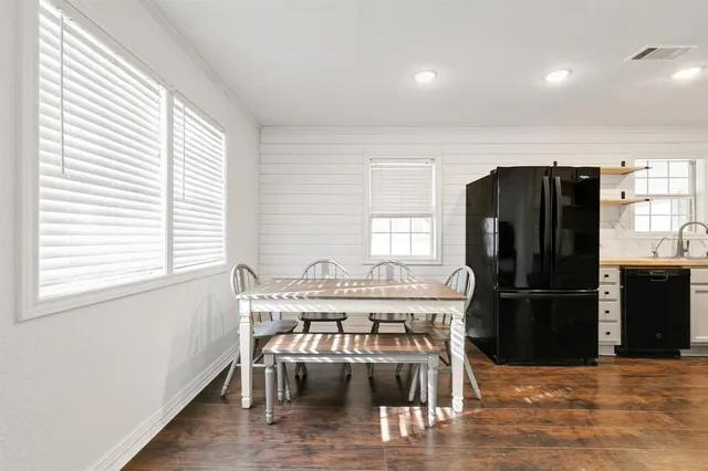 a kitchen with stainless steel appliances wooden floor dining table and chairs