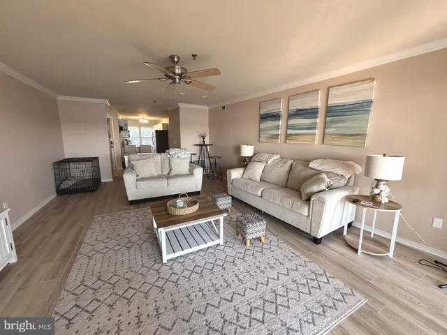 a view of an empty room with wooden floor a fireplace and a window
