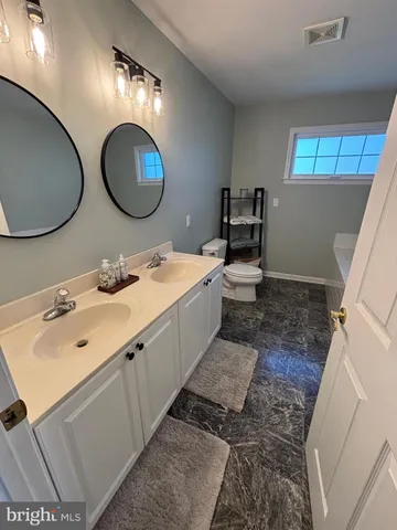 a spacious bedroom with two beds and a desk