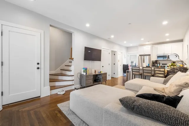 a large bedroom with bed tv and couches
