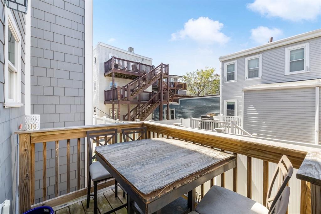 20 Grimes Street, Unit SF Boston, MA 02127 - Photo 14 of 15 a view of a roof deck with table and chairs with wooden floor and fence
