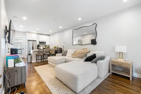 a living room with furniture and a kitchen view
