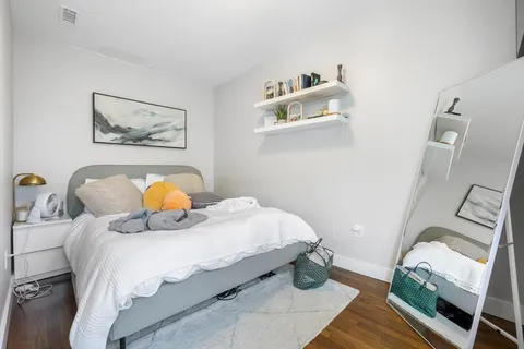 a bedroom with a bed and wooden floor