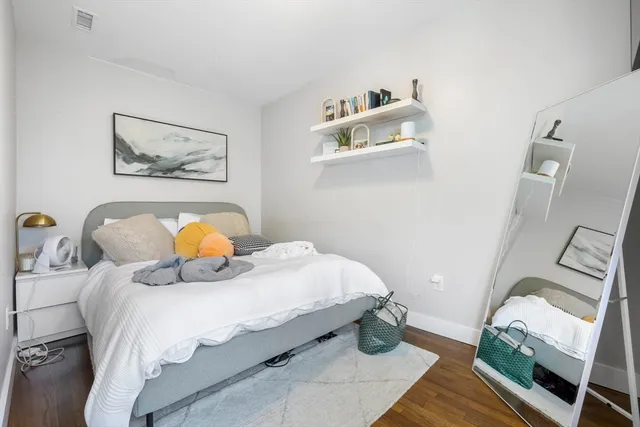 a bedroom with a bed and wooden floor