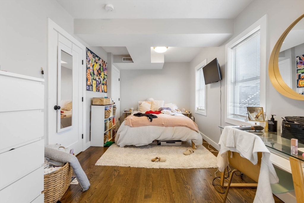 20 Grimes Street, Unit SF Boston, MA 02127 - Photo 8 of 15 a bedroom with a bed wooden floor and a large window