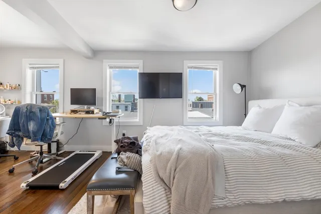 a bedroom with a bed and a flat tv screen on the dresser