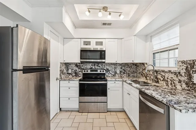 a kitchen with stainless steel appliances granite countertop a refrigerator stove and microwave