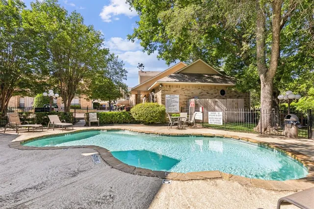 a front view of a house with a garden and trees