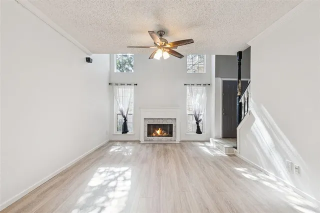 a view of a livingroom with a fireplace a ceiling fan and brick wall