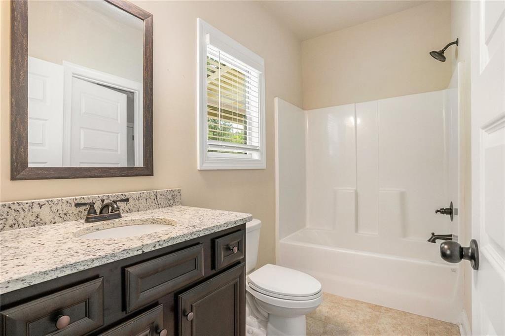 381 Homestead Circle Forsyth, GA 31029 - Photo 15 of 49 a bathroom with a granite countertop sink toilet and shower