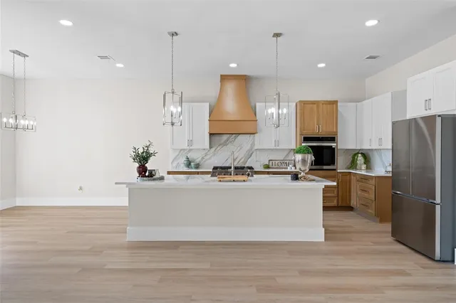 a view of kitchen with stainless steel appliances granite countertop refrigerator sink and stove