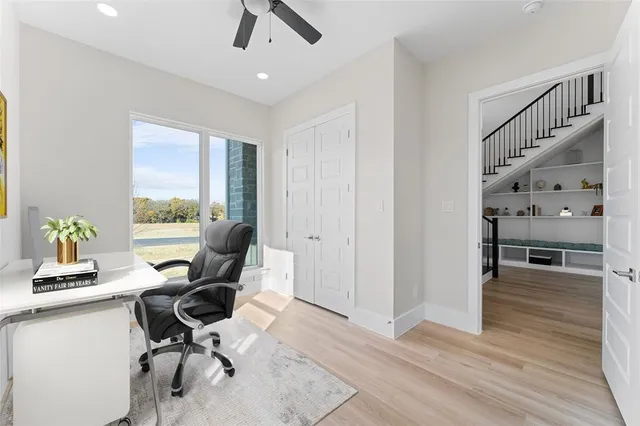 a view of a workspace with furniture and a window