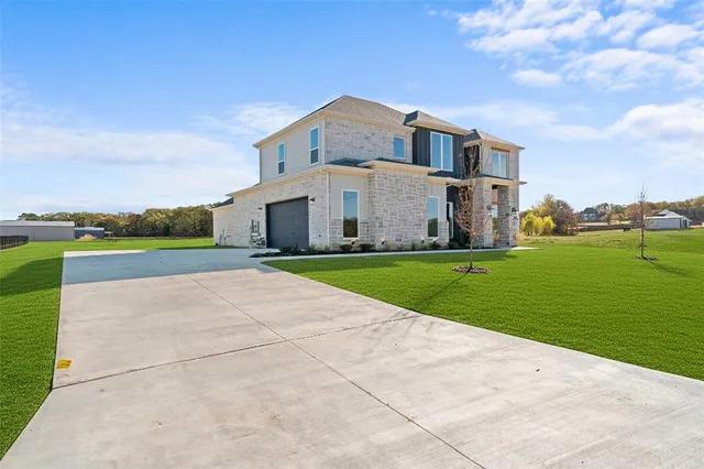 a view of a house with a big yard and large trees