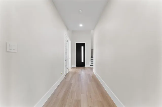 a view of a hallway with wooden floor