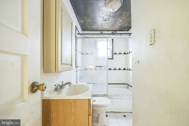 a bathroom with a granite countertop sink vanity mirror and toilet