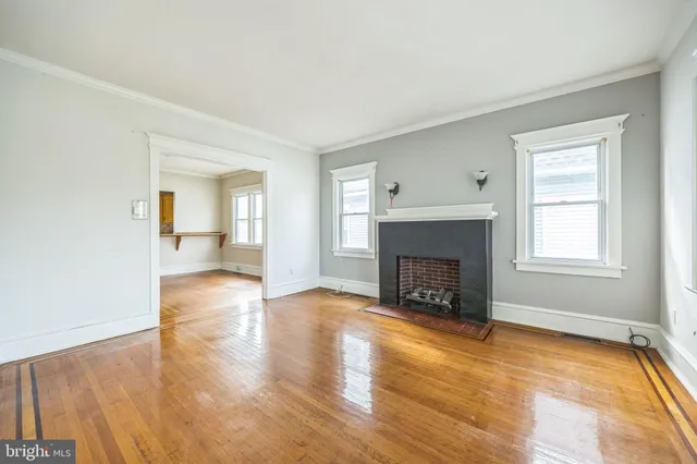 a view of a livingroom with wooden floor and a fireplace
